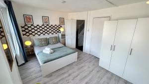 a small bedroom with a bed and white cabinets at Stylish 2-Bedroom Flat in Barbican Centre near Farringdon with Rooftop Terrace in London