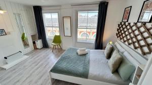a bedroom with a large bed and two windows at Stylish 2-Bedroom Flat in Barbican Centre near Farringdon with Rooftop Terrace in London