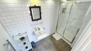 a bathroom with a shower and a sink and a mirror at Stylish 2-Bedroom Flat in Barbican Centre near Farringdon with Rooftop Terrace in London