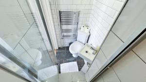 a bathroom with a toilet and a glass shower at Stylish 2-Bedroom Flat in Barbican Centre near Farringdon with Rooftop Terrace in London