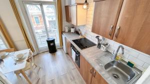 a small kitchen with a sink and a table at Stylish 2-Bedroom Flat in Barbican Centre near Farringdon with Rooftop Terrace in London
