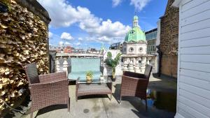 a balcony with a table and chairs and a building at Stylish 2-Bedroom Flat in Barbican Centre near Farringdon with Rooftop Terrace in London