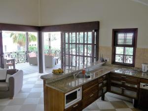 uma cozinha com um lavatório e uma bancada em Blue Bay Beach Villa 14 em Blue Bay