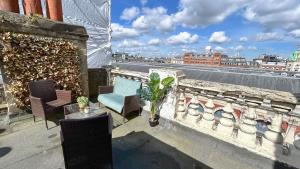 a balcony with chairs and a blue couch on a building at Stylish 2-Bedroom Flat in Barbican Centre near Farringdon with Rooftop Terrace in London