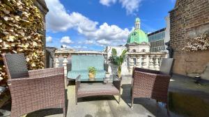 a table and chairs on a balcony with a building at Stylish 2-Bedroom Flat in Barbican Centre near Farringdon with Rooftop Terrace in London