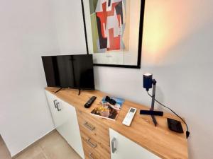 a living room with a television on a dresser at Mono Limone dx con corte, posto auto ed aria condizionata a due passi dal mare in Marcelli