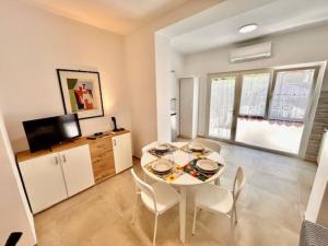 a dining room with a white table and chairs at Mono Limone dx con corte, posto auto ed aria condizionata a due passi dal mare in Marcelli