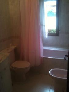 a bathroom with a toilet and a sink and a window at Habitaciones López Azcona in Noja +25 photos