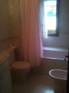 La salle de bains est pourvue de toilettes, d'un lavabo et d'une fenêtre. dans l'établissement Habitaciones López Azcona, à Noja