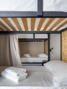 two beds in a room with two bunk beds at Piccolo Catalunya Hostel in Alghero