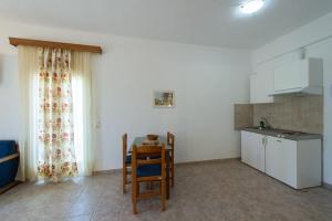 a kitchen with a table and chairs and a small kitchen at Agios Efrem Studios in Parga