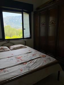 a bedroom with a bed and a window with flowers at Holiday home in Vlorë