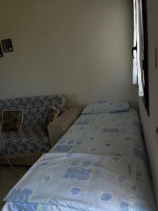 a small bedroom with a bed and a couch at Holiday home in Vlorë