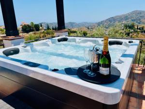 a hot tub with a bottle of wine and glasses at Villa El Dorado B&B and Wellness in Cómpeta