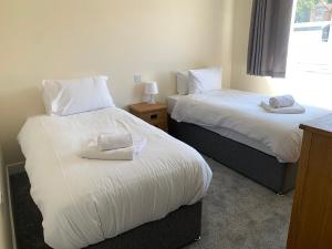 two beds sitting next to each other in a room at West Beach - Holiday Apartments in Westward Ho