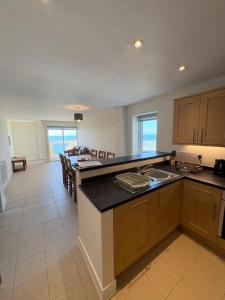 a kitchen with a table and a dining room at West Beach - Holiday Apartments in Westward Ho