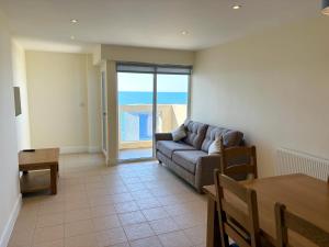 a living room with a couch and a table at West Beach - Holiday Apartments in Westward Ho