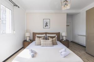 a bedroom with a large white bed with two night stands at Majestueux Appartement 2 pièces à Hydra in Hydra