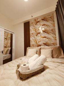 ein weißes Bett mit Handtüchern darauf vor einer Marmorwand in der Unterkunft Regalia's Pod in Trece Martires