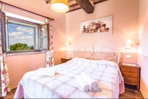 a bedroom with a white bed and a window at Olivo Cottage - Monti 1824 in Casole dʼElsa +24 photos
