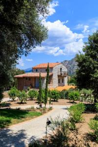 un grand bâtiment en pierre avec des arbres devant lui dans l'établissement A Mandria di Murtoli, à Sartène