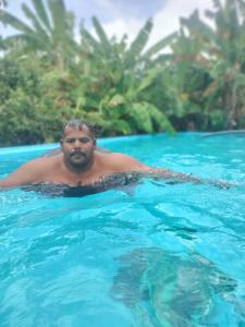 Un hombre está nadando en una piscina en SNS Organic Farm Stay, en Sidlaghatta
