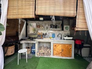 a kitchen with a stove and a sink in a room at The Anahaw Cabin in Tanauan
