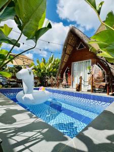 a villa with a pool in front of a house at The Anahaw Cabin in Tanauan +6 photos