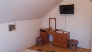 a room with a dresser and a tv on the wall at Guesthouse Tomas in Čatrnja