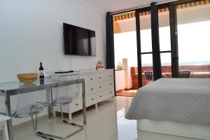 - une chambre avec une table en verre et un lit dans l'établissement Listen the BAY - 230, à Costa del Silencio