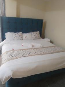1 cama grande con cabecero azul en una habitación en Charles place, en Ruiru
