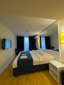 Un dormitorio con una cama grande y un espejo grande. en Orbi aparthotel, en Batumi