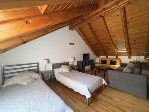 een slaapkamer met twee bedden en een bank in een kamer bij BPirineos-La Tea in Benasque