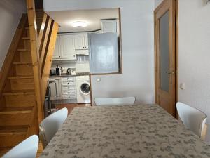 een kamer met een tafel en stoelen en een keuken bij BPirineos-La Tea in Benasque