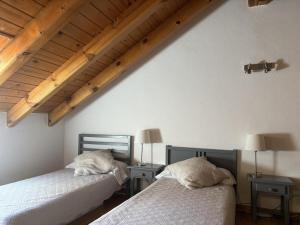 2 bedden in een kamer met houten plafonds bij BPirineos-La Tea in Benasque +5 foto's