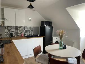 a kitchen with a table and a black refrigerator at Morlaix appartement centre-ville in Morlaix