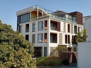 a white building with a balcony on top of it at Guanlu Art Hotel in Huadu
