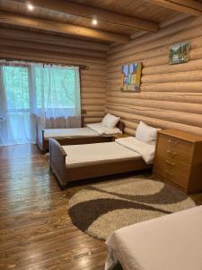 a room with two beds in a log cabin at Апартаменти з 2 спальними кімнатами in Mukacheve