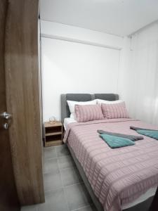 a bedroom with two beds with pink and green sheets at IL Paradiso potok akva park in Jagodina