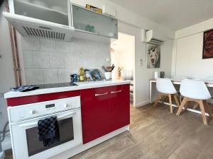 a kitchen with a red and white stove top oven at Le refuge du pont in Imphy