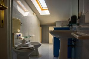 a bathroom with a sink and a toilet and a skylight at La Casa di Lucia in Marcelli +26 photos