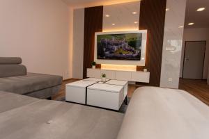 a living room with a bed and a couch at 1-Bedroom LUX Apartment with Balcony & Underground Parking Garage in Spišská Nová Ves