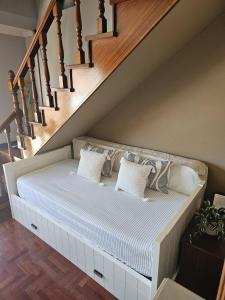 a bed under the stairs with pillows on it at Coqueto Duplex en Vilagarcía de Arousa centro in Vilagarcia de Arousa