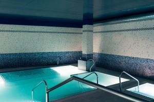 a swimming pool with a hot tub in a building at Hotel Mercure Jardines de Albia in Bilbao