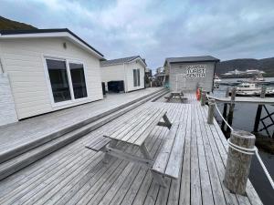 a wooden deck with a bench on top of a marina at Port Nordkapp Mobile House in Skarsvåg +2 photos