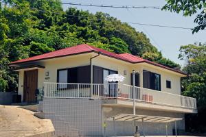 a house with a balcony and an umbrella at La maison du sud d'awaji in Minamiawaji