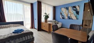 a bedroom with a bed and a dining room with a table at Orient Holiday in Sunny Beach +33 photos