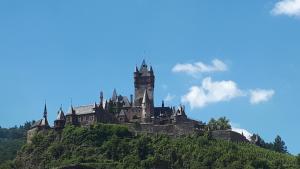 an castle on top of a hill with a clock tower at Pension Elisabeth in Cochem
