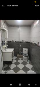 a bathroom with a toilet and a sink at hébergement T3 Equipe in Baïnem Falaise +12 photos