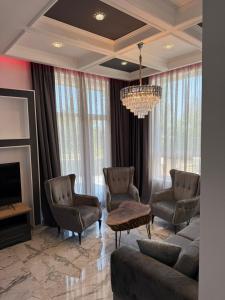 a living room with a couch and chairs and a chandelier at Aurum Villas Smokinya Beach 2 in Sozopol